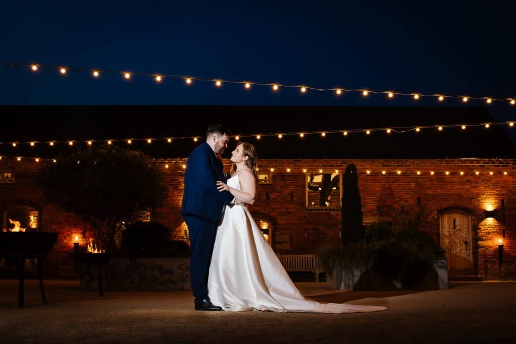 Yorkshire_wedding_photographer_wedding_couple_underneath_the_festoon_lighting_at_grangefields_yorkshire_wedding_venue_cripps_&_co
